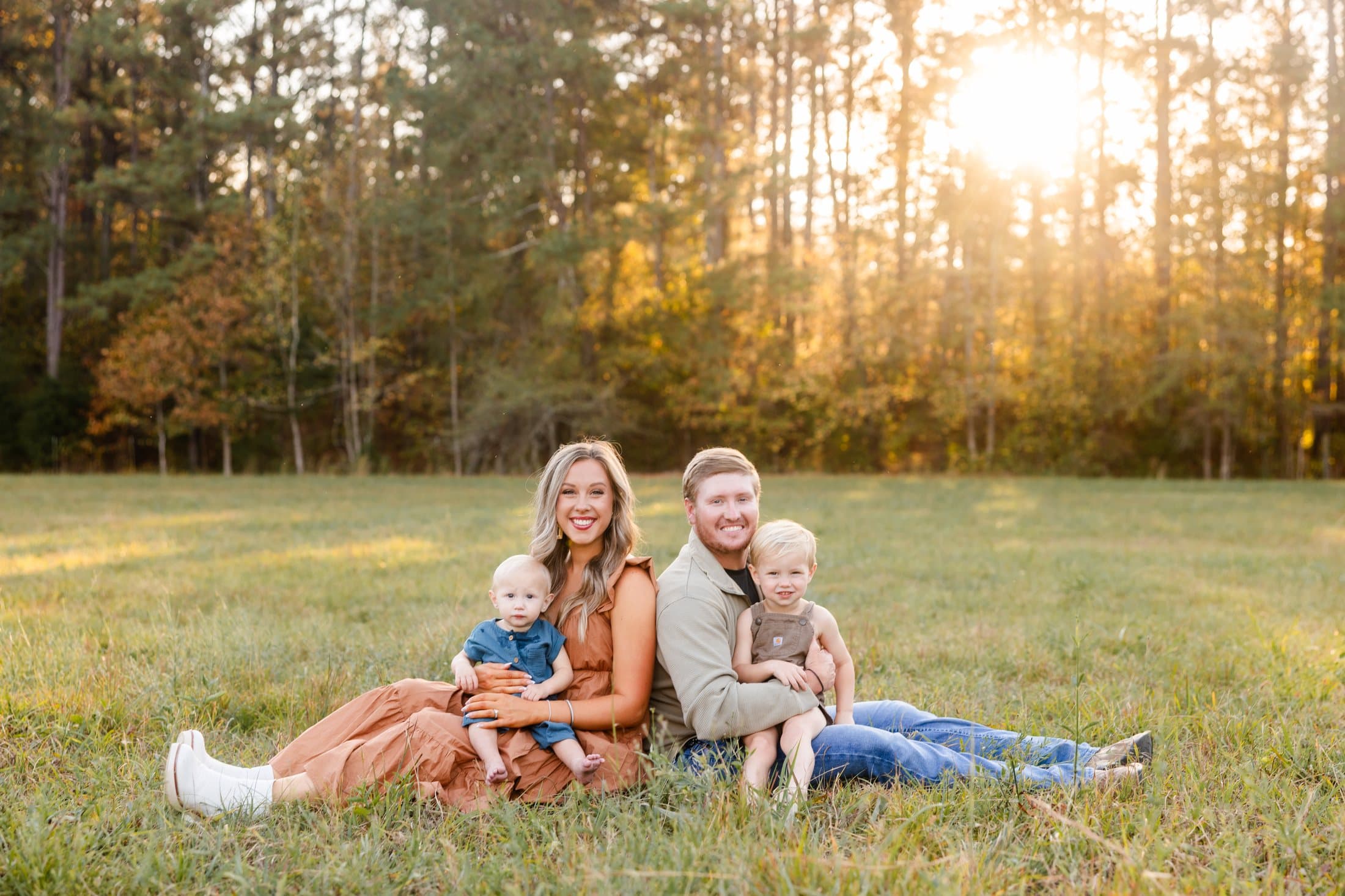 Steven and his wife with their two boys in a field at sunset